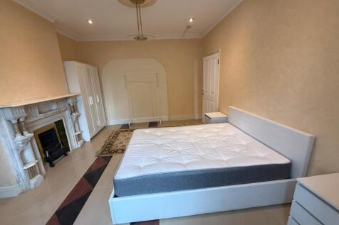 Spacious master bedroom with elegant fireplace...