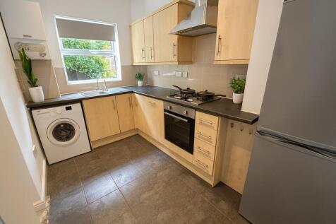 A bright and clean kitchen featuring wooden cab...
