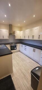 Bright modern galley kitchen with white fitted ...