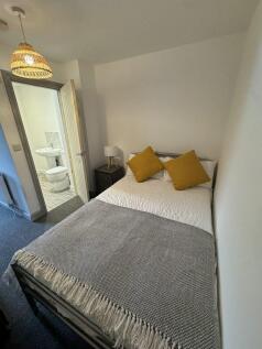 Cozy double bedroom featuring a neatly made bed...