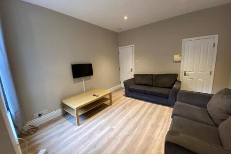 Bright, neutrally decorated living room with tw...