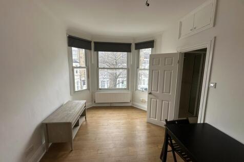Bright bedroom with bay window and wooden floor...