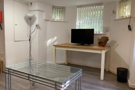 Bright, simply furnished living area with a TV ...