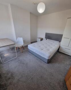 Bright bedroom with large desk and storage spac...