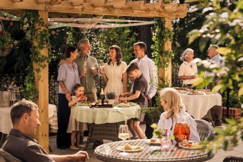 a group of people standing around a table with food on it