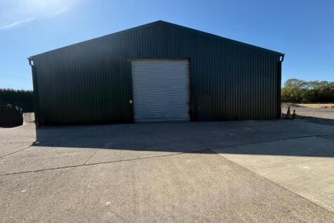Front of building with electric roller shutter door and separate personnel door