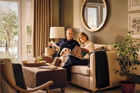 a man and woman sitting on a couch with a dog