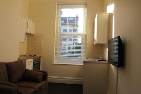 Compact studio living area with kitchen and win...
