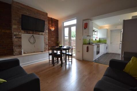 Bright open-plan living area with exposed brick...