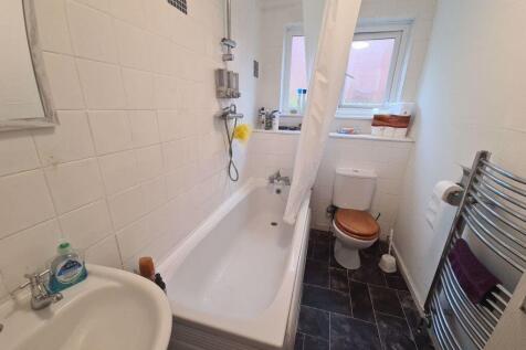 Bright, clean bathroom with a bathtub, shower, ...