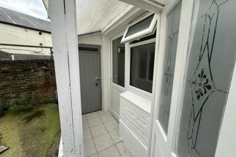 Covered porch/entrance with tiled step and side...