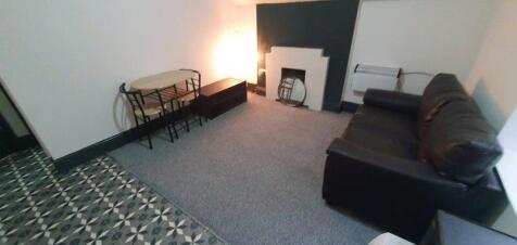 Cozy living room with a dark leather sofa, patt...