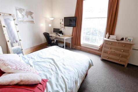 Bright bedroom with large desk and ample storag...