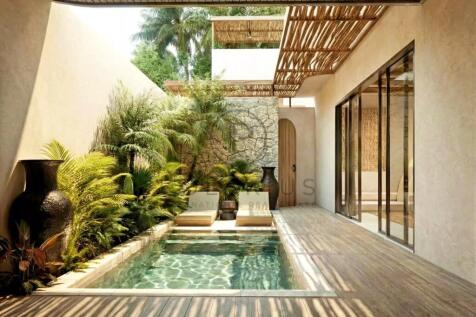 Modern outdoor patio with a private pool and lush 