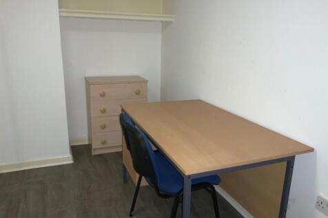 Compact single bedroom with a sturdy wooden des...