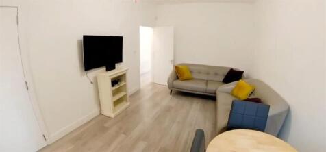 Bright lounge with a large sofa and flat-screen...