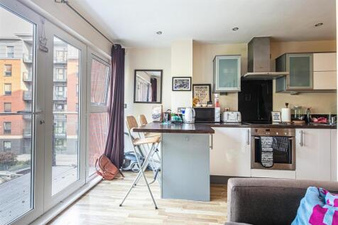 Bright kitchen with breakfast bar and balcony...