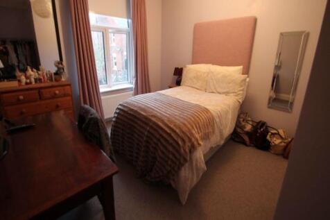 A cozy student bedroom featuring a single bed w...