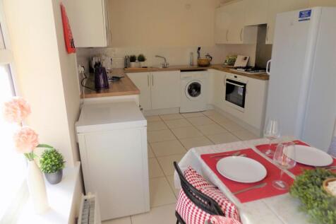 Bright modern galley kitchen with white cabinet...