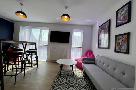 Bright, modern living room with a long grey sof...