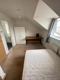 A well-lit, tidy bedroom with a comfortable dou...