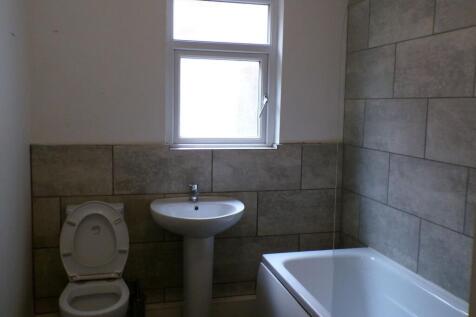 Bright tiled bathroom with a white pedestal sin...