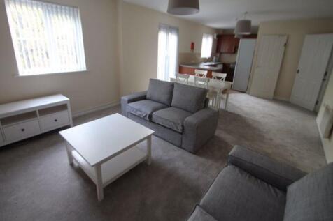 Bright, carpeted living room with matching grey...