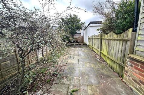 Private paved garden pathway with mature shrubs...