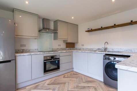 Modern fitted kitchen with marble-effect workto...