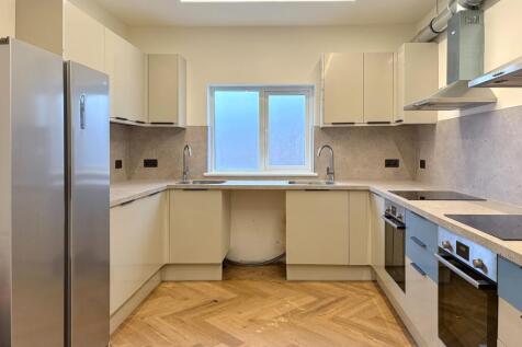 Bright, modern kitchen with sleek white cabinet...