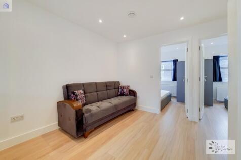 Bright living area with plush sofa and wood flo...