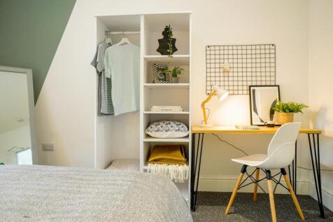 A bright and tidy double bedroom featuring a st...