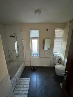 Bright, modern bathroom with a full-size bathtu...