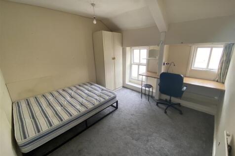 Bright bedroom with large desk and storage spac...