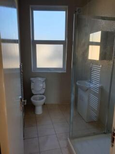 Modern bathroom with walk-in shower and window....