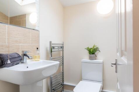 Bright, modern bathroom with a white basin, con...