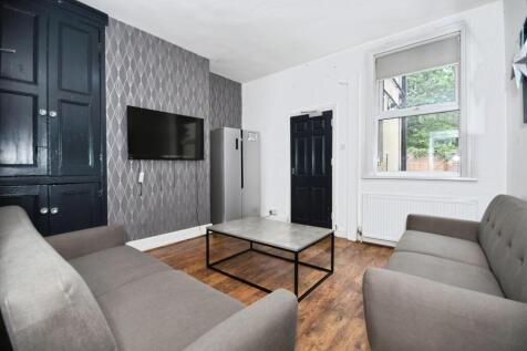 Contemporary shared lounge with paired sofas fa...