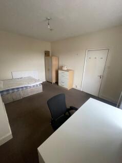 A spacious, well-lit living room featuring a co...