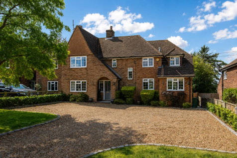 Sunlit estate home with green lawns.png