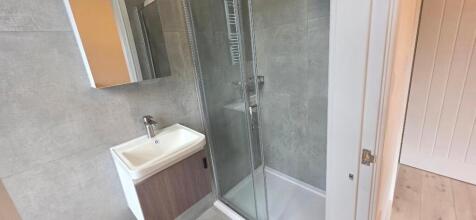 Modern shower suite with sleek grey tiling...
