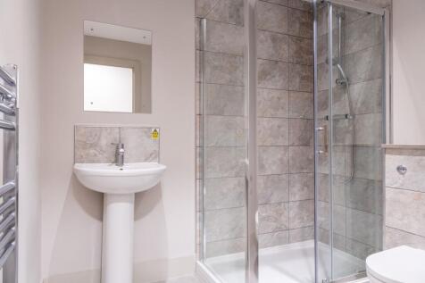 Modern bathroom with stylish tiles and glass sh...