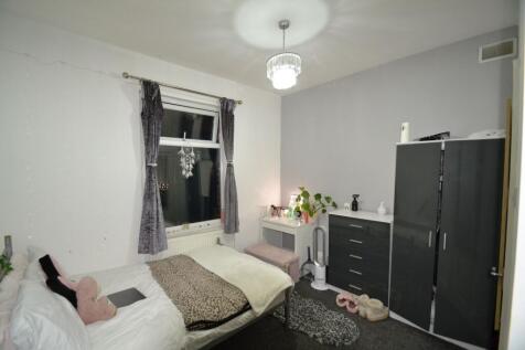 Bright, neatly furnished bedroom with a double ...