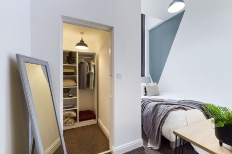 A stylish and well-lit double bedroom with a fi...