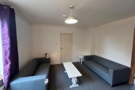 Bright communal lounge with two modern grey sof...