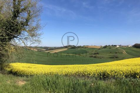 A scenic landscape with rolling green hills, a fie