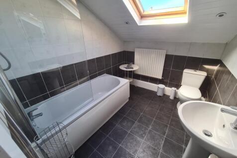 Bright and modern bathroom suite featuring a ba...