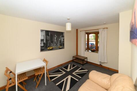 Bright, tidy living room with a comfy leather s...