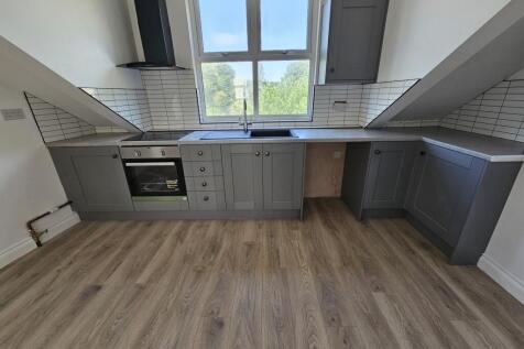 Modern kitchen with grey shaker-style cabinets,...
