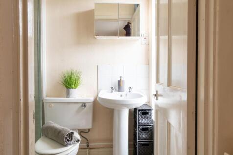 Bright, tidy bathroom with a pedestal sink, mir...