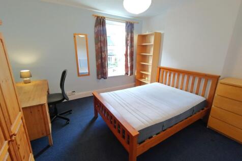 Bright bedroom with ample study space and stora...